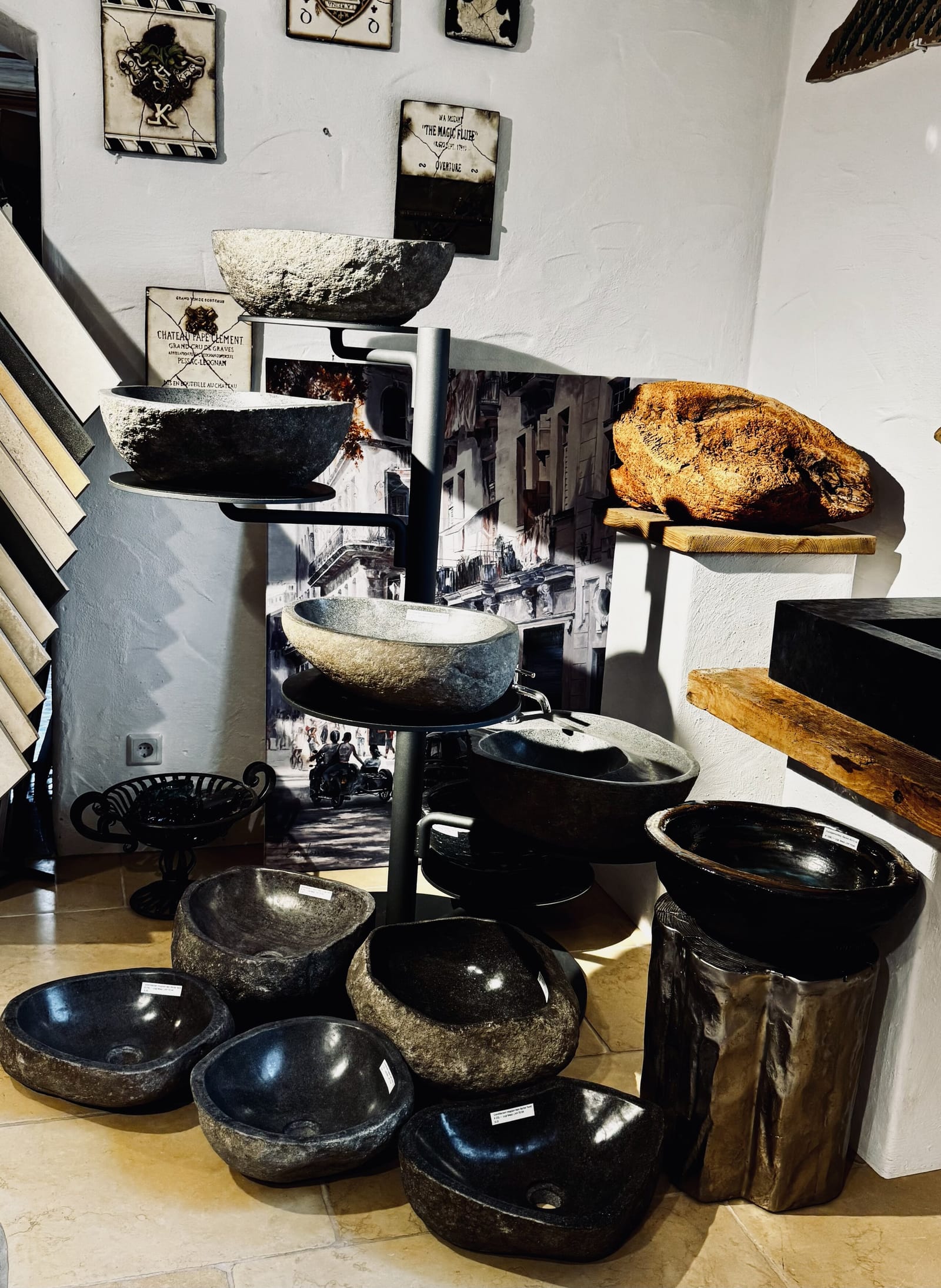 Etagere mit Waschschalen aus Flussstein und Naturstein in verschiedenen Formen und Schliffen.