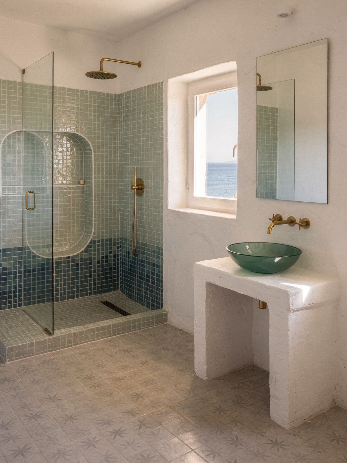 Bad mit blaugrünem Glasmosaik in der Dusche und gemusterten Zementfliesen am Boden