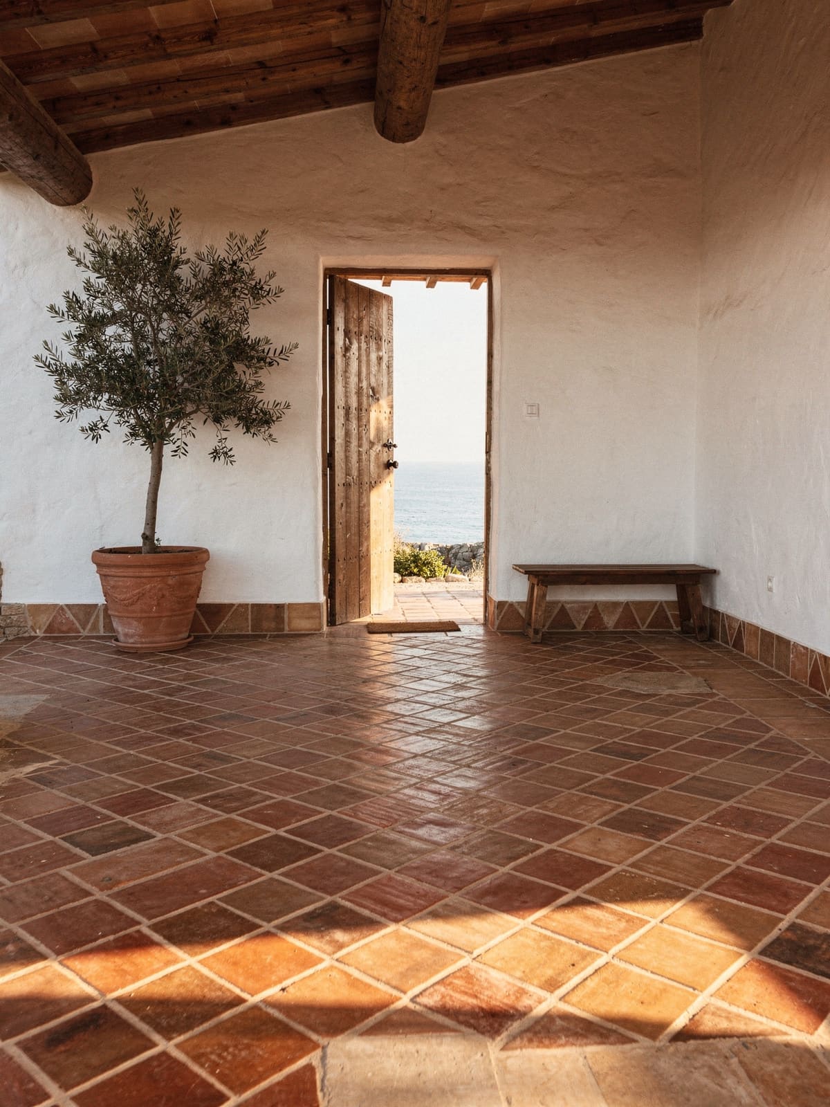 Eingangsbereich einer Finca mit diagonal verlegtem Cottoboden und weiß gekalkten Wänden