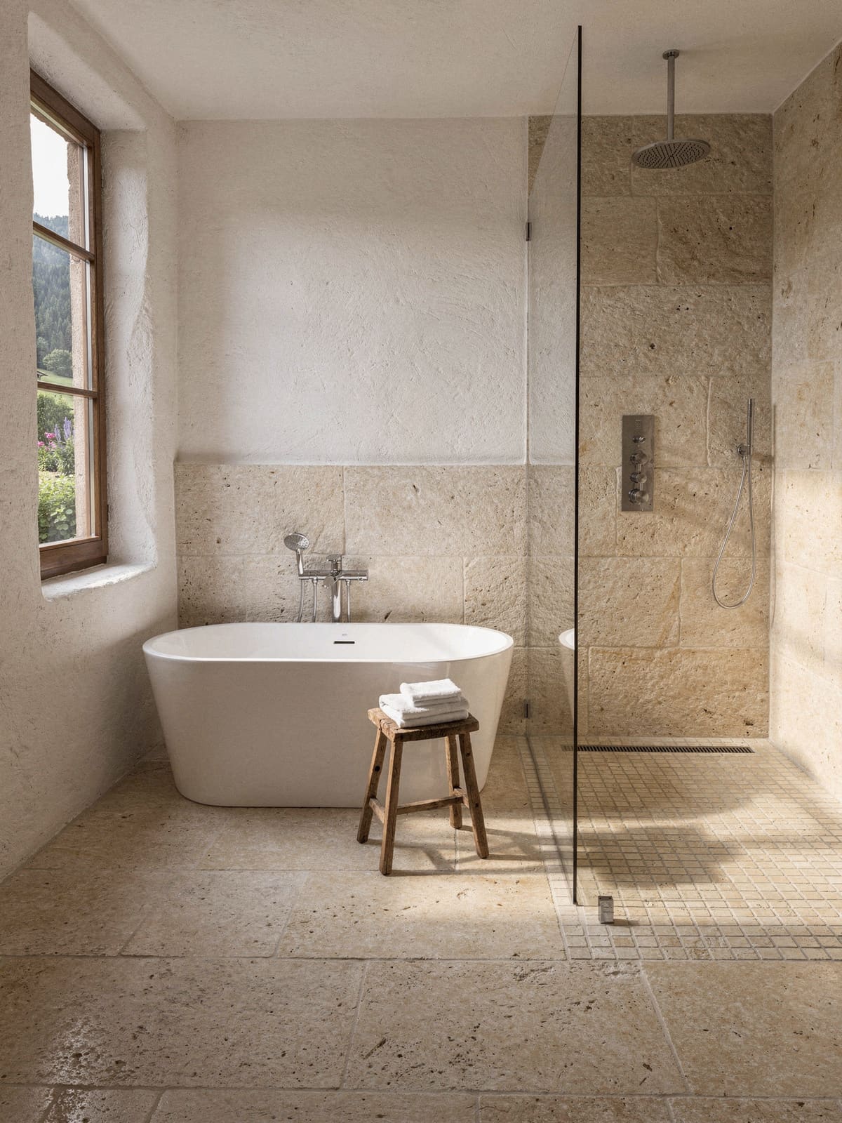 Landhaus-Bad mit Natursteinboden, freistehender Wanne und Mosaik in der bodengleichen Dusche