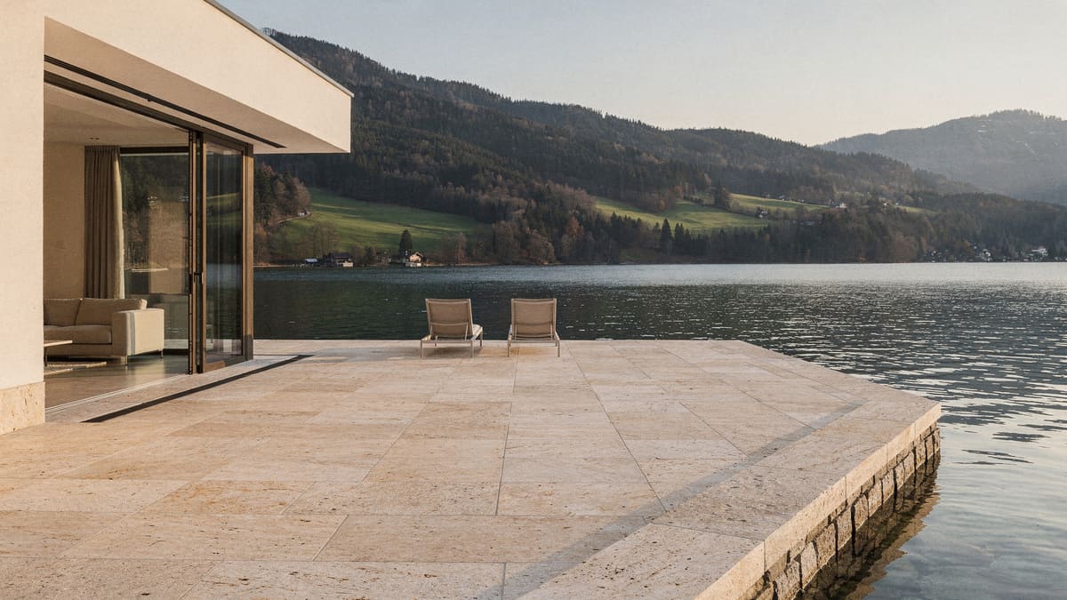 Seeterrasse mit sandgestrahltem Kalkstein, flächenbündiger Übergang zum Wohnraum, Blick über den Tegernsee